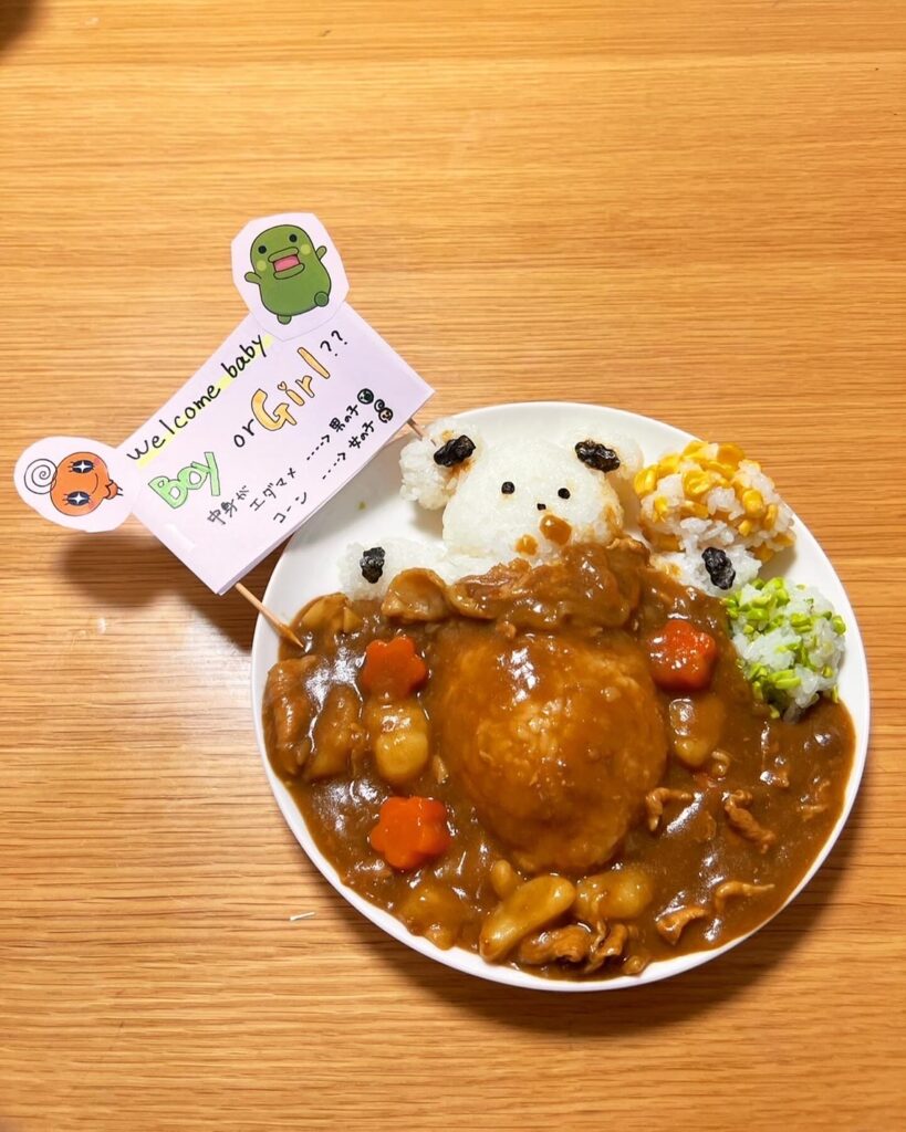 プレートに盛り付けられたカレーライス。ご飯で作られたクマの顔が添えられ、カレーの上には『Boy or Girl!?』と書かれた旗が立っている。